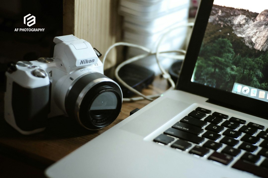 Photographer editing photos on a laptop with a camera nearby